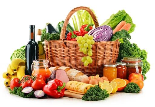 Basket of fresh fruit, vegetables, bread and preserves