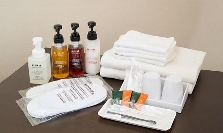 Guest amenity kit with pump bottles, folded towels, slippers, cups and dental kits
