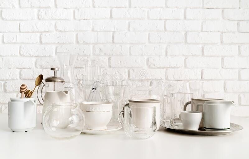 White porcelain tea and coffee set against a white brick wall